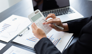 a woman using a calculator and paper based charts